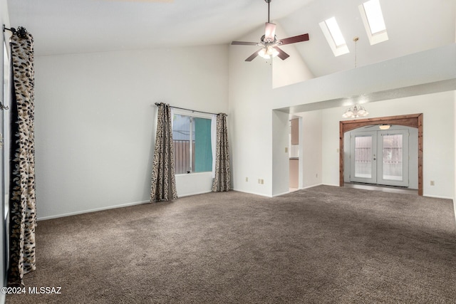 unfurnished living room featuring carpet flooring, ceiling fan, french doors, and a skylight