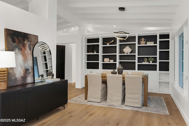 dining area featuring vaulted ceiling with beams and light hardwood / wood-style floors