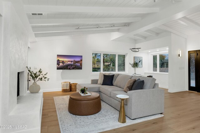 living room with wood ceiling, vaulted ceiling with beams, plenty of natural light, and wood-type flooring