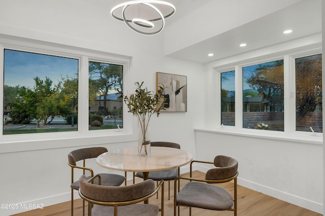 dining room featuring wood-type flooring, a notable chandelier, and a wealth of natural light