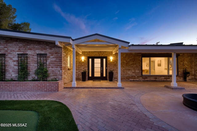 exterior entry at dusk with a patio