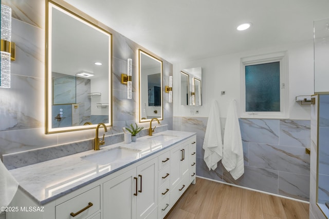 bathroom featuring wood-type flooring, vanity, and tile walls