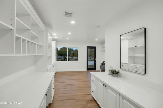 interior space with light wood-type flooring and white cabinetry