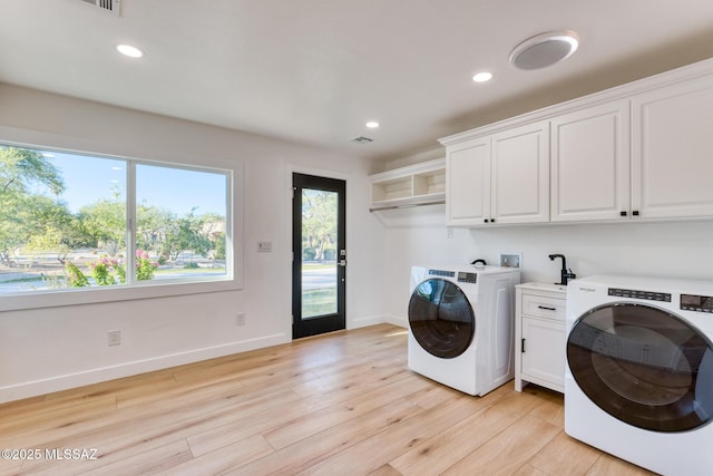 clothes washing area with washer hookup, cabinets, and light wood-type flooring