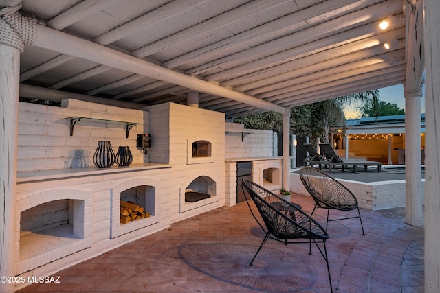 patio terrace at dusk with an outdoor fireplace