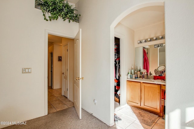 corridor with sink and light tile patterned floors