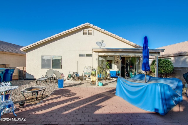 rear view of house featuring a patio and an outdoor fire pit