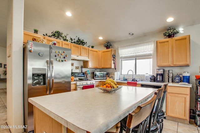 kitchen featuring light brown cabinets, a center island, stainless steel appliances, and sink