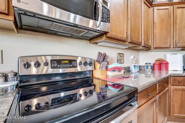 kitchen featuring light stone countertops and appliances with stainless steel finishes