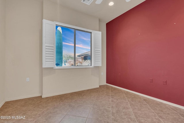 spare room with ceiling fan and light tile patterned floors