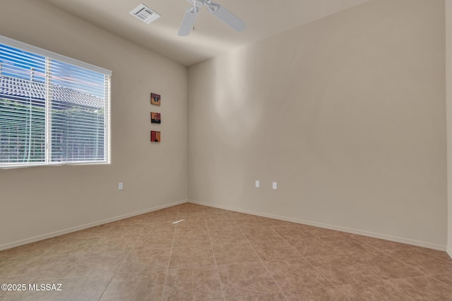 tiled spare room featuring a wealth of natural light and ceiling fan