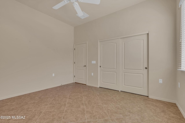 unfurnished bedroom with ceiling fan, a closet, light tile patterned floors, and lofted ceiling