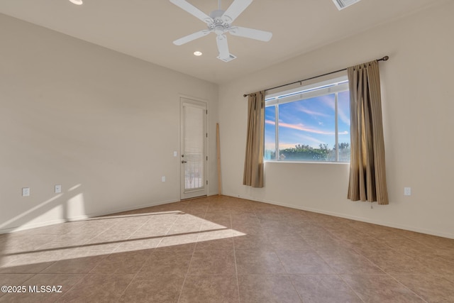 empty room with ceiling fan and light tile patterned flooring