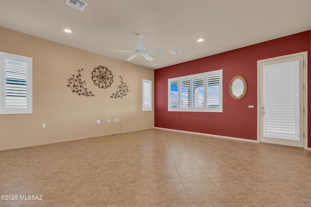 tiled empty room featuring ceiling fan