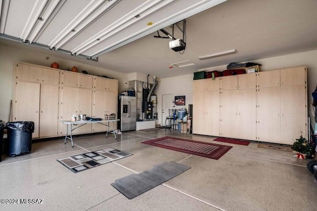 garage featuring stainless steel fridge with ice dispenser and a garage door opener