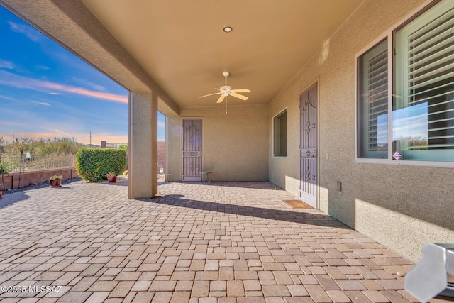 patio terrace at dusk featuring ceiling fan