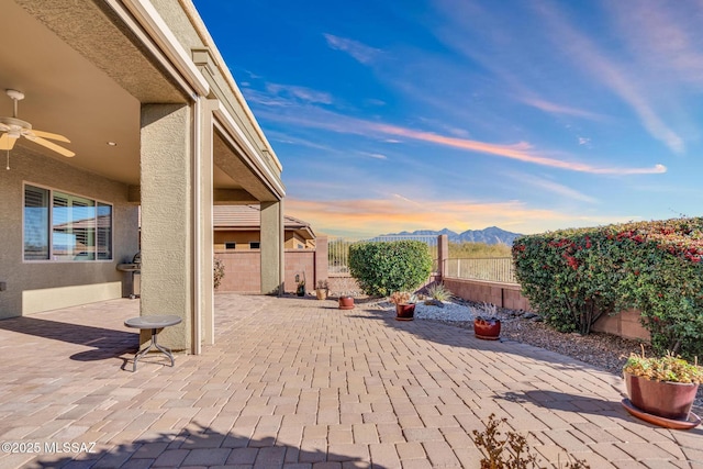 patio terrace at dusk featuring ceiling fan