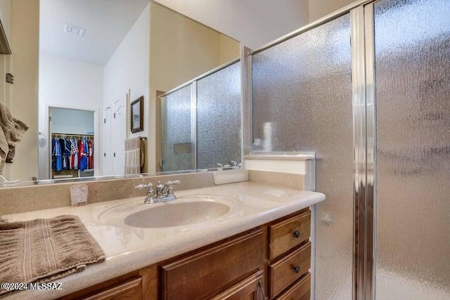 bathroom with a shower with door and vanity