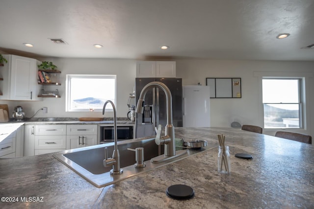 kitchen featuring open shelves, dark countertops, recessed lighting, white cabinets, and stainless steel fridge