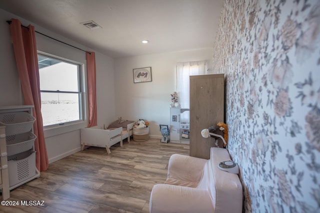 living area with recessed lighting, visible vents, baseboards, and wood finished floors