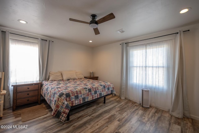 bedroom featuring dark wood-style floors, multiple windows, and recessed lighting