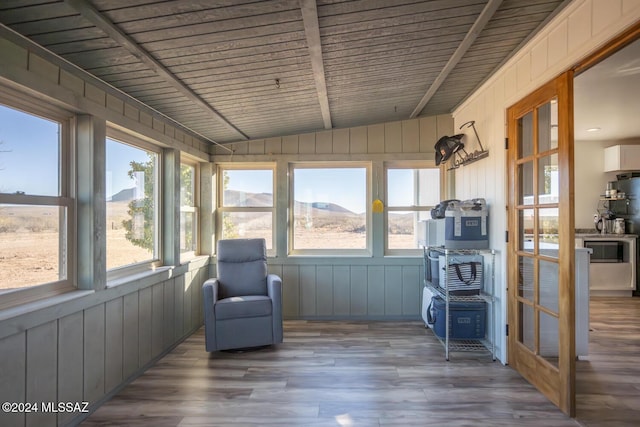 sunroom with vaulted ceiling, a wealth of natural light, and a mountain view