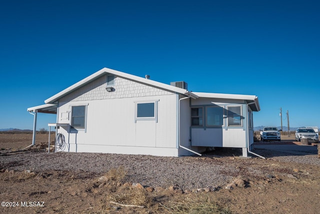 back of house featuring a carport and cooling unit