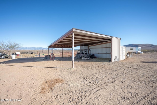 view of outdoor structure featuring a carport, an outdoor structure, and a mountain view