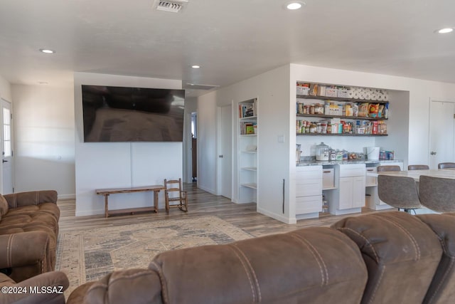 living area featuring light wood-type flooring, visible vents, and recessed lighting