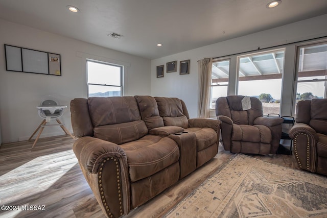 living area featuring visible vents, light wood-type flooring, and recessed lighting
