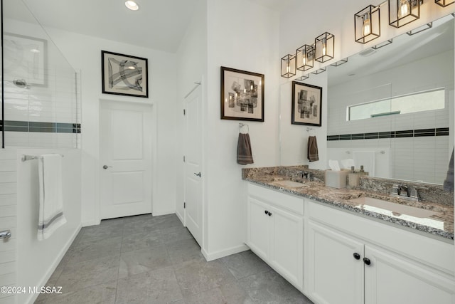 full bath with double vanity, baseboards, a walk in shower, and a sink