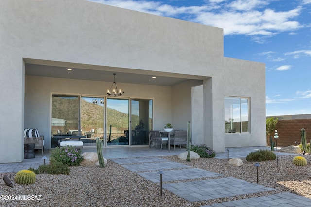 rear view of property with stucco siding, fence, and a patio