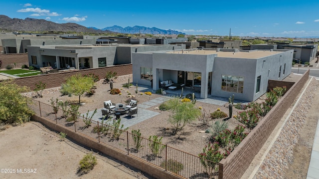 rear view of property featuring a patio area, a fenced backyard, stucco siding, and a mountain view