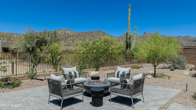 view of patio with a fire pit, a fenced backyard, and a mountain view