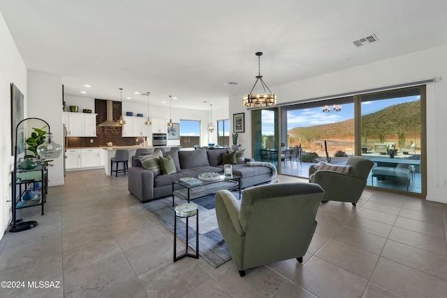 living room with a mountain view, light tile patterned floors, and a notable chandelier