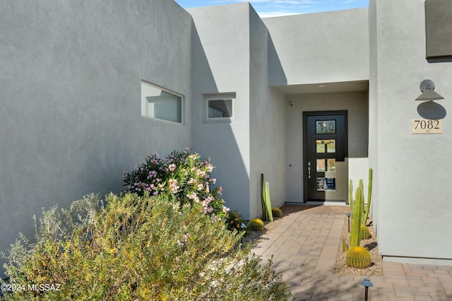 entrance to property featuring stucco siding