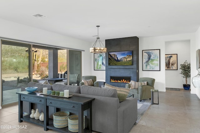 tiled living room with a fireplace and a notable chandelier