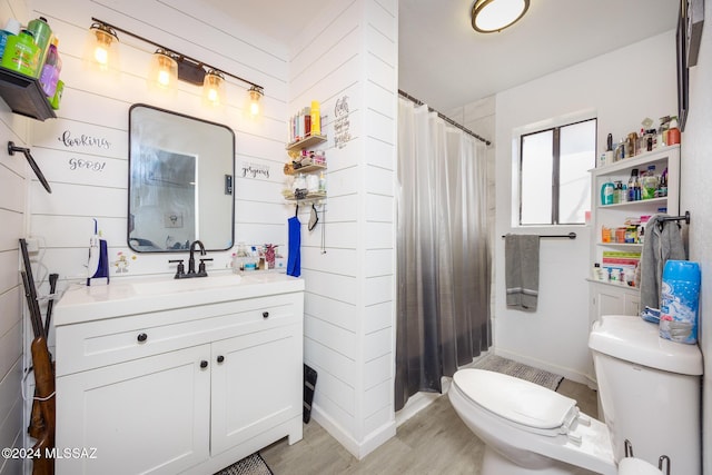 bathroom with hardwood / wood-style floors, vanity, wood walls, toilet, and walk in shower