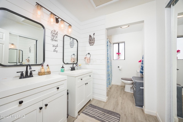 bathroom featuring walk in shower, ornamental molding, vanity, hardwood / wood-style flooring, and toilet