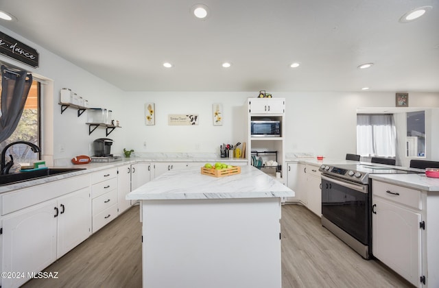 kitchen featuring a center island, sink, white cabinetry, and stainless steel appliances