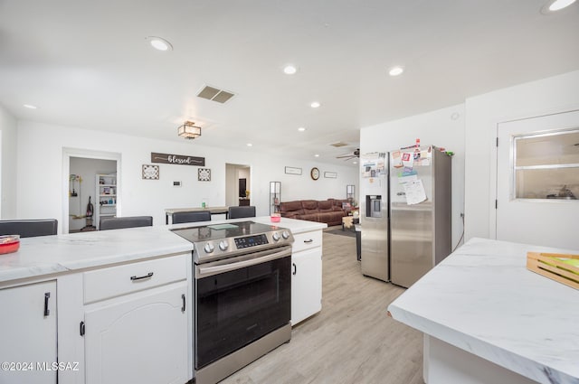 kitchen featuring white cabinetry, light hardwood / wood-style flooring, ceiling fan, and stainless steel appliances