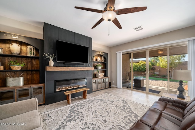 tiled living room featuring ceiling fan, a fireplace, and built in features