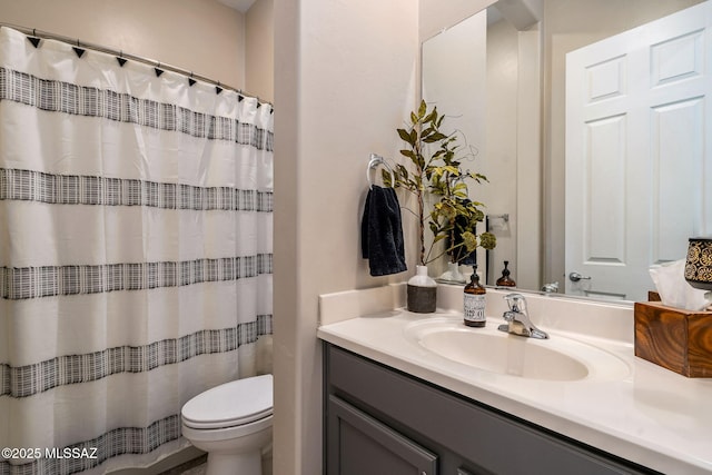 bathroom featuring walk in shower, vanity, and toilet