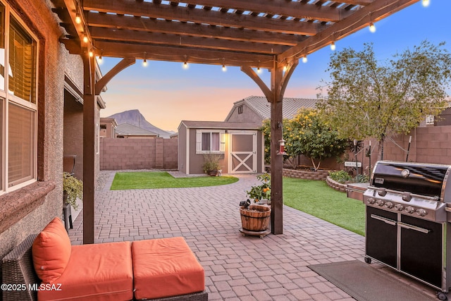 patio terrace at dusk with a pergola, a grill, a yard, and a storage shed