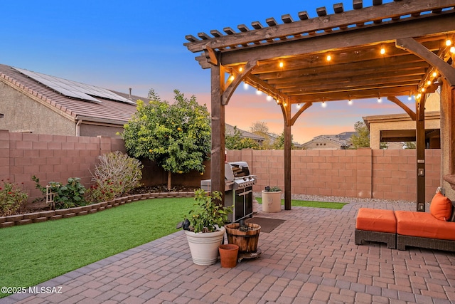 patio terrace at dusk with a yard and a pergola