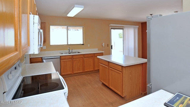 kitchen with sink, light hardwood / wood-style floors, plenty of natural light, and appliances with stainless steel finishes