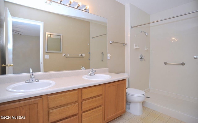 bathroom featuring tile patterned floors, vanity, toilet, and walk in shower