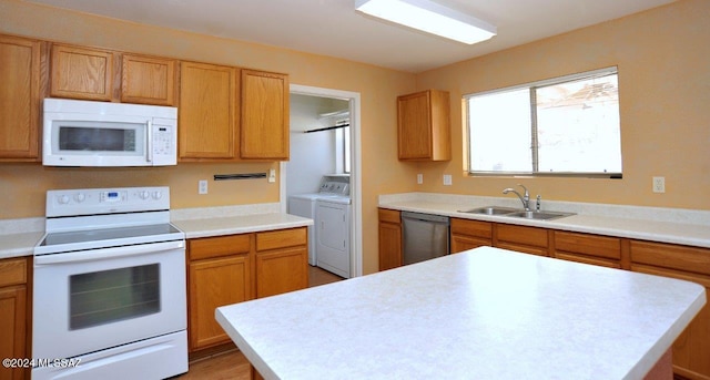 kitchen with a center island, white appliances, sink, and separate washer and dryer