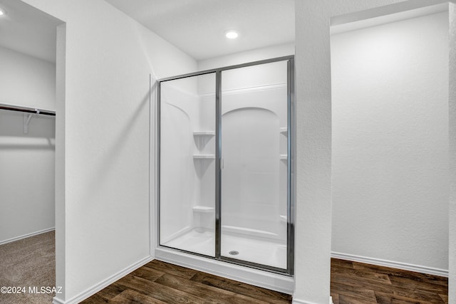 bathroom featuring a shower with door and hardwood / wood-style flooring