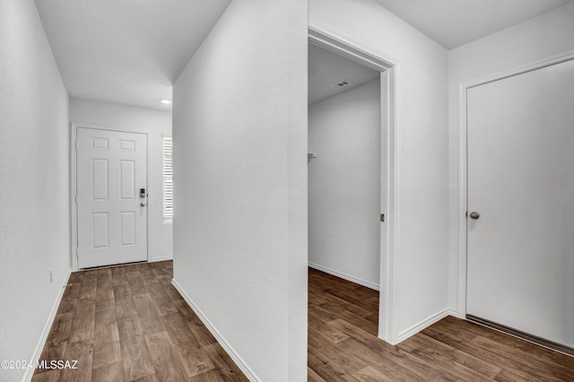 hallway with hardwood / wood-style flooring